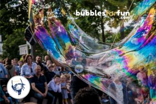 eine große Seifenblase mit Publikum im Hintergrund